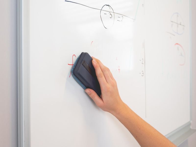 person cleaning a whiteboard