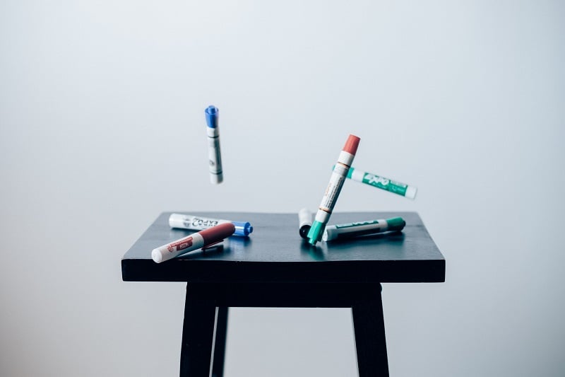 whiteboard markers falling onto a table
