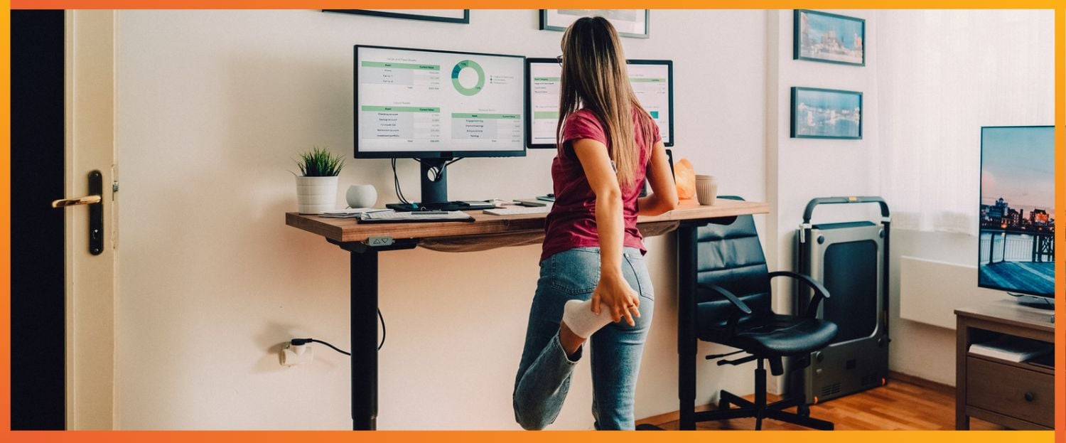 women standing at a standing office desk holding a stretch