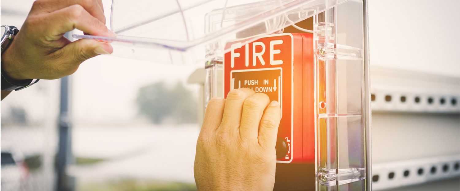 man pulling a fire alarm handle