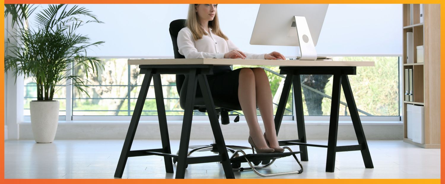 Woman sitting at her office desk with her feet comfortably sat on a footrest
